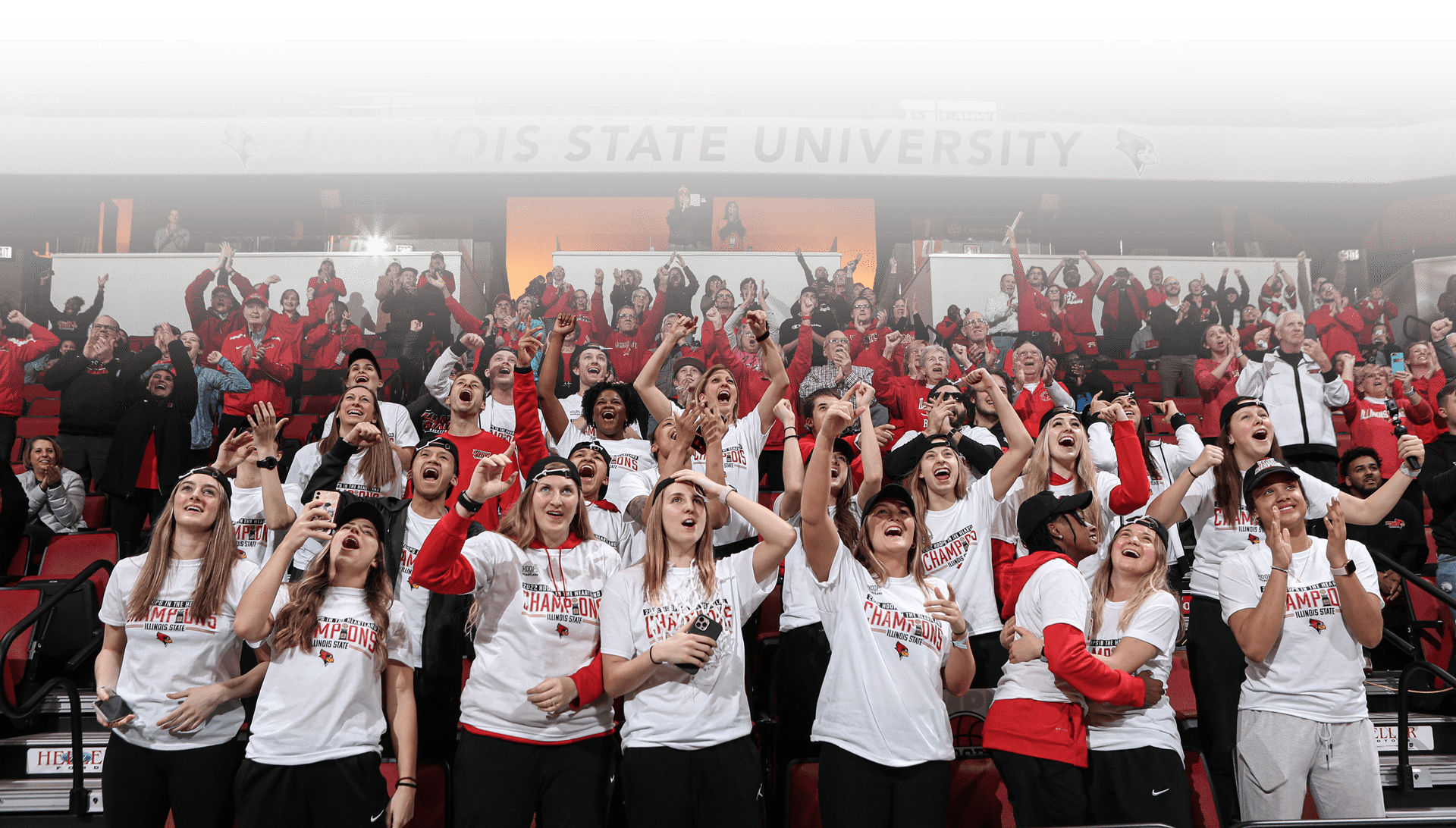 Women's basketball team celebrating in the stands with fans